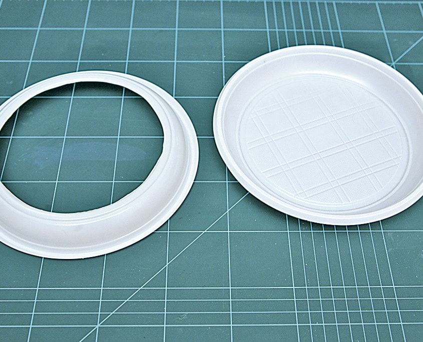 Ortası kesilip halka haline getirilmiş beyaz plastik tabak ve yanında bütün tabak