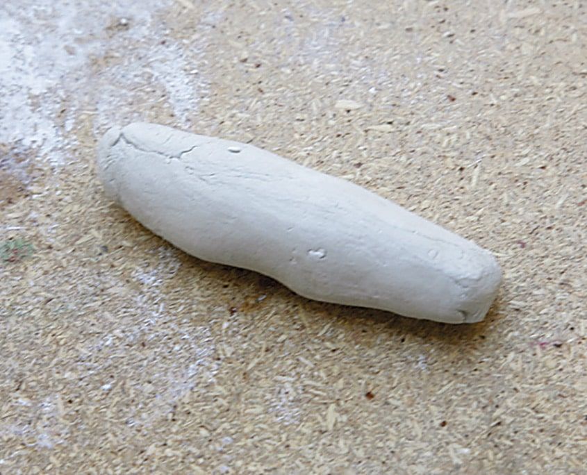 Masada yuvarlanarak uzatılmış tek parça beyaz kil: ayının kolları için hazırlanan silindir