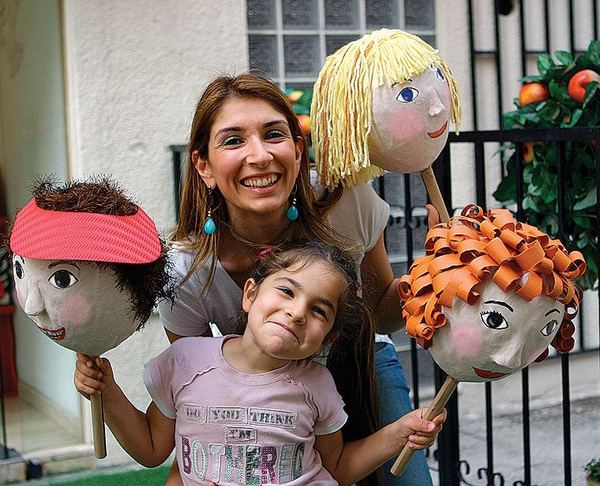 Balon Kuklalar: kırmızı, sarı yün ve turuncu kurdele saçlı üç kağıt hamuru kafa kukla, bir yetişkin ve çocukla