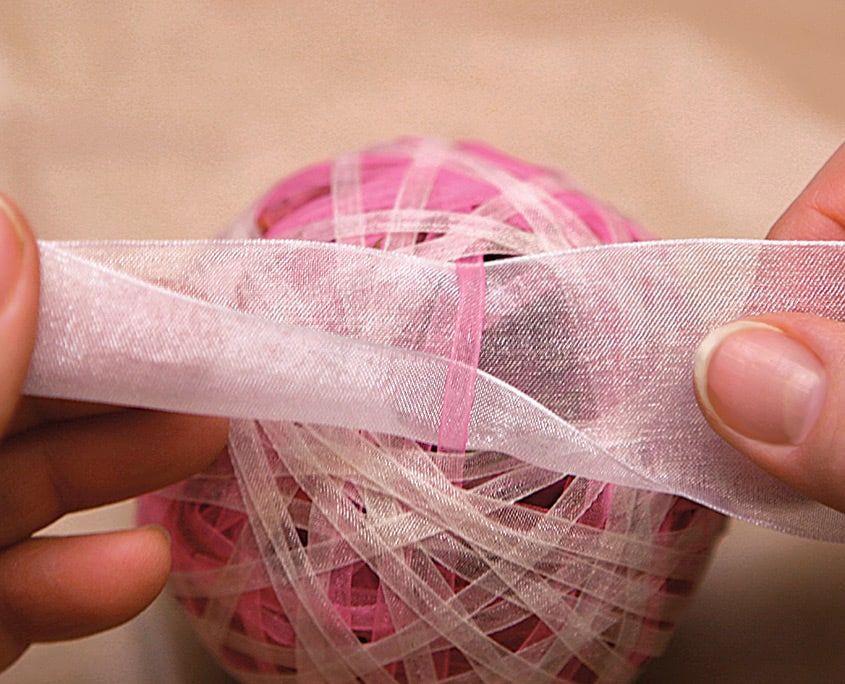 Doldurulan topun çevresine geniş beyaz organze kurdele geçiriliyor