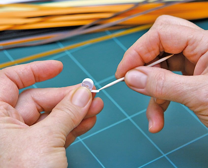 Beyaz kağıt şerit quilling çubuğunda sarılarak küçük bir rulo oluşturuluyor