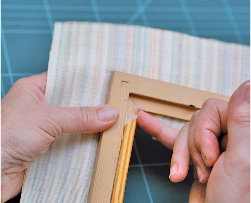 Parmaklarla kumaş çerçevenin iç yüzüne bastırılarak yapıştırılıyor