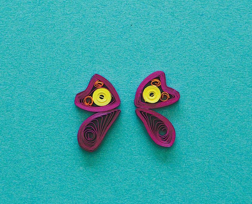 Turkuaz zeminde yan yana duran iki mor quilling kelebek kanadı, içlerinde sarı spiraller
