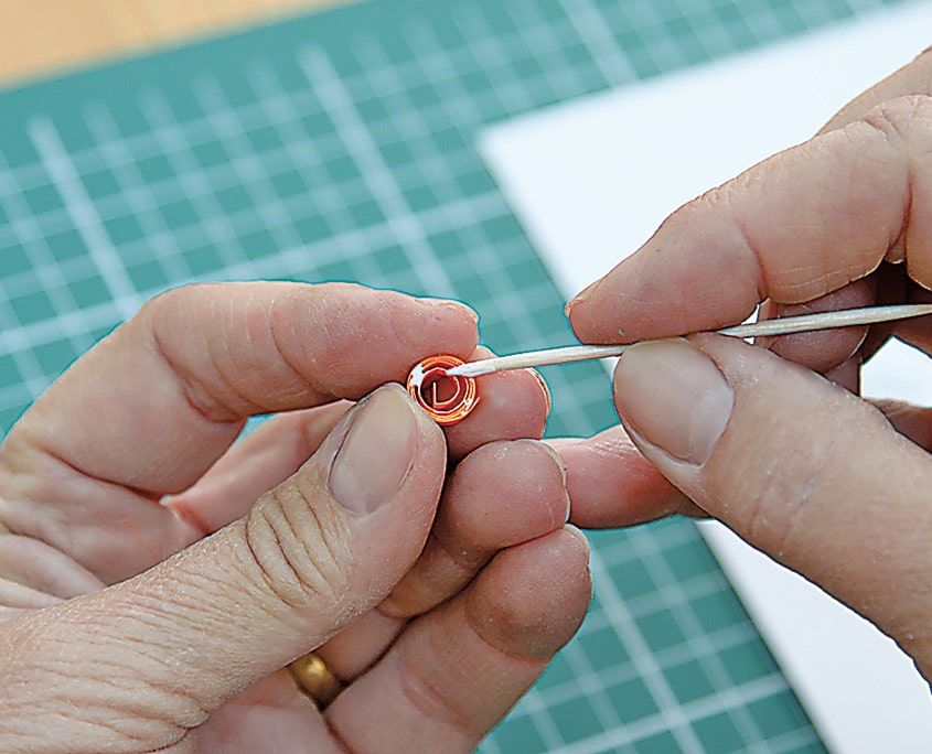 Turuncu ve kırmızı quilling şeridi kürdanın ucuna sarılarak küçük bir rulo yapılıyor