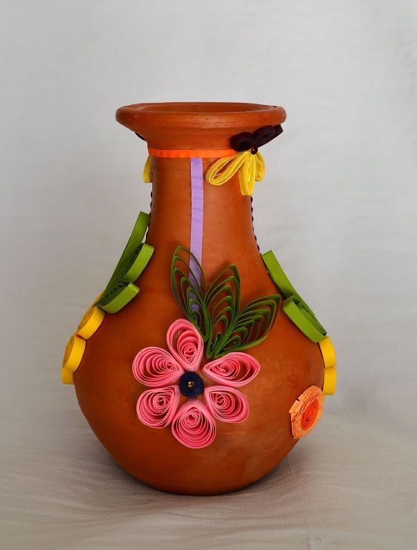 Turuncu toprak vazonun gövdesinde pembe çiçek ve yeşil yapraklardan quilling süsleme