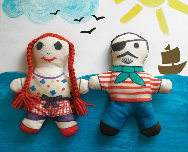 Korsan bebekler: örgülü kızıl saçlı kız bez bebek ve göz bantlı çizgili tişörtlü korsan, deniz fonunda