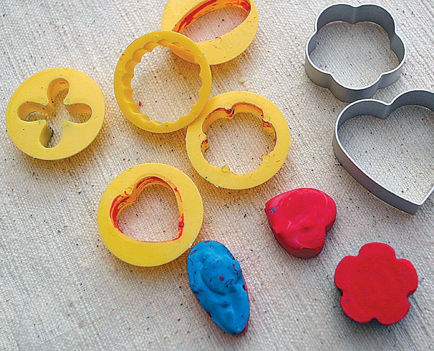 Kalıplardan çıkarılmış kalp, çiçek ve yüz biçimli pastel boyalar, yanlarında plastik ve metal kalıplar