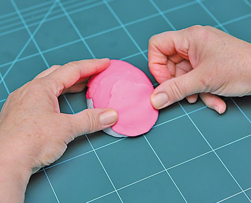 Pembe oyun hamuru strafor yumurtanın üzerine parmaklarla bastırılarak kaplanıyor