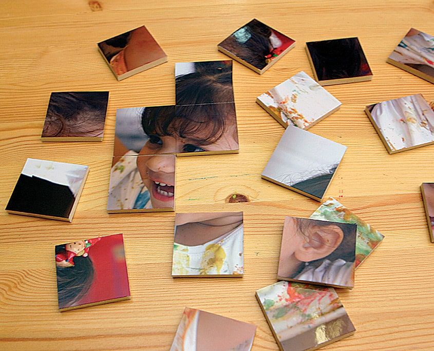 Ahşap masaya dağılmış kare fotoğraf yap-boz parçaları, bazıları ters dönmüş