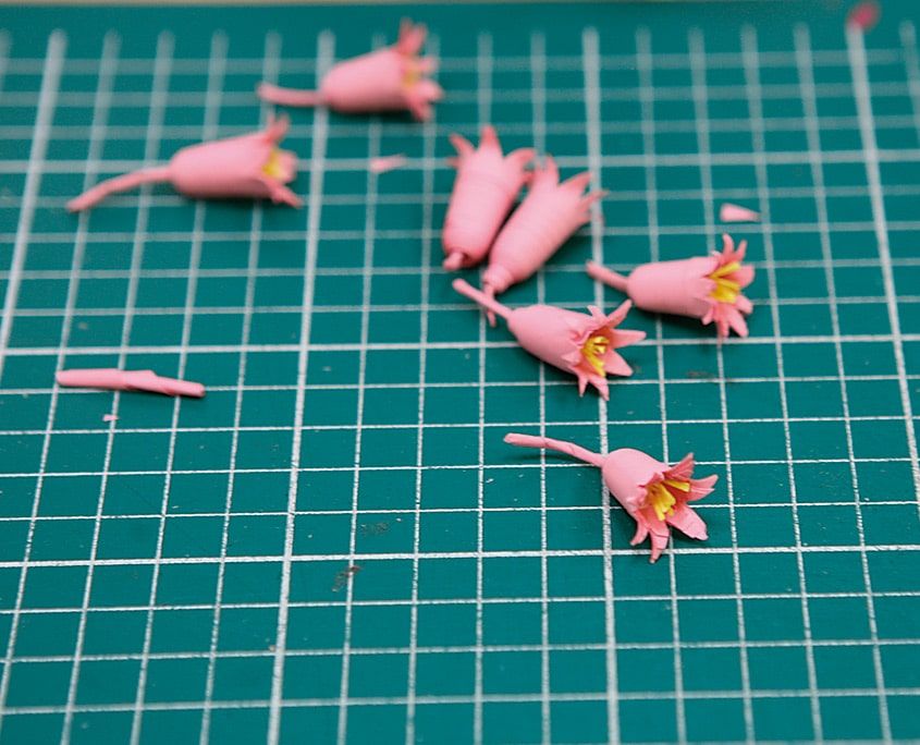 Kesim altlığında sarı göbekli, uçları kıvrık, saplı pembe quilling çan çiçekleri