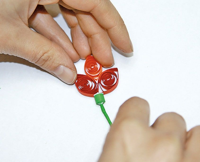 Kırmızı quilling lale başı, yeşil sapın ucundaki halkaya yapıştırılıyor