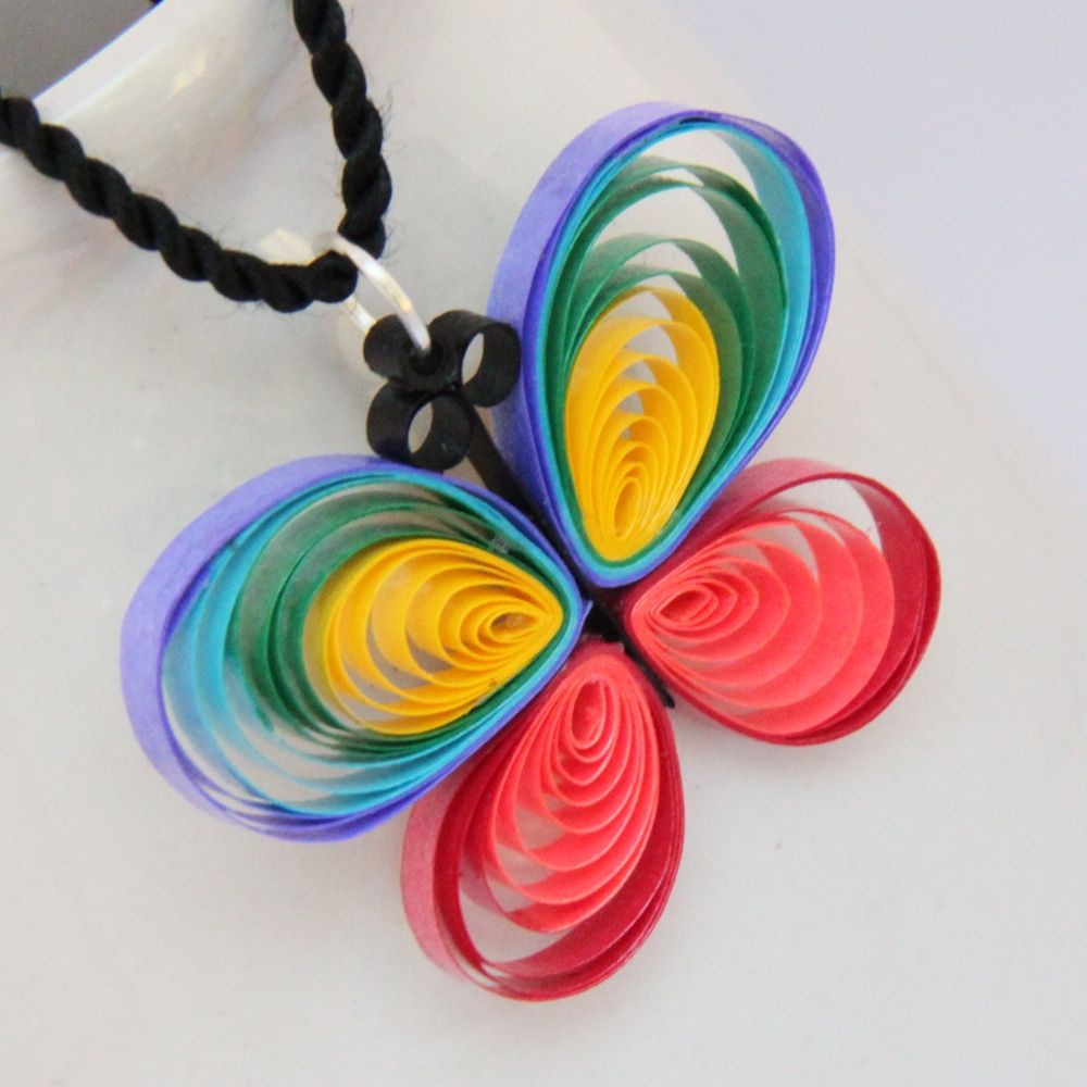 Siyah kordona takılı, gökkuşağı renklerinde kağıt şeritlerden yonca biçimli quilling kolye ucu
