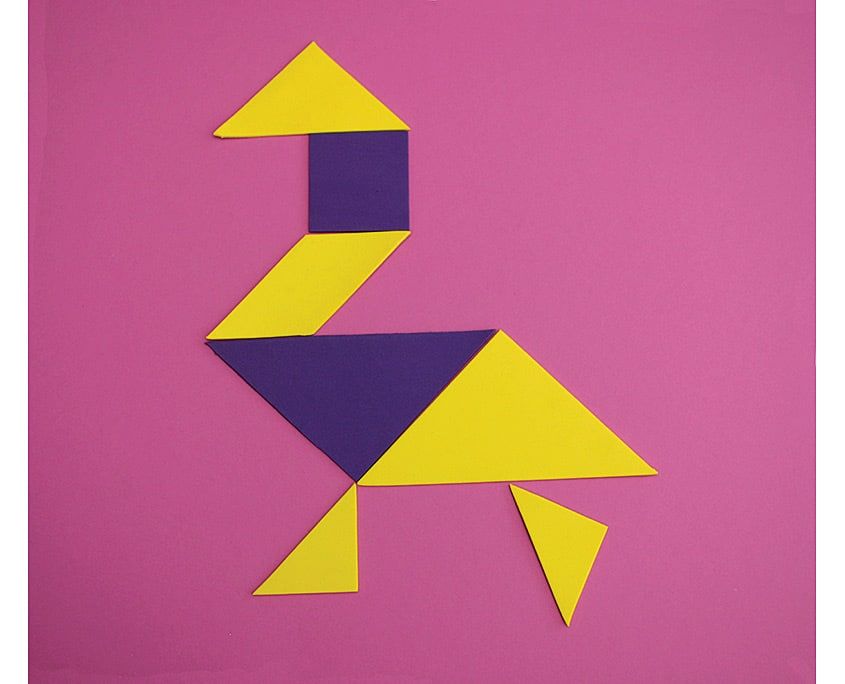 Sarı ve lacivert tangram parçalarından uzun boyunlu, iki bacaklı kuş figürü, pembe zeminde