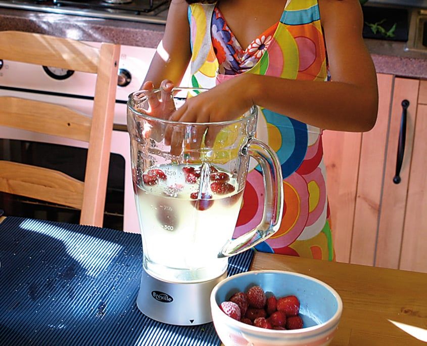 Limon şerbeti dolu blender haznesine çilekler ekleniyor, önde kasede taze çilekler