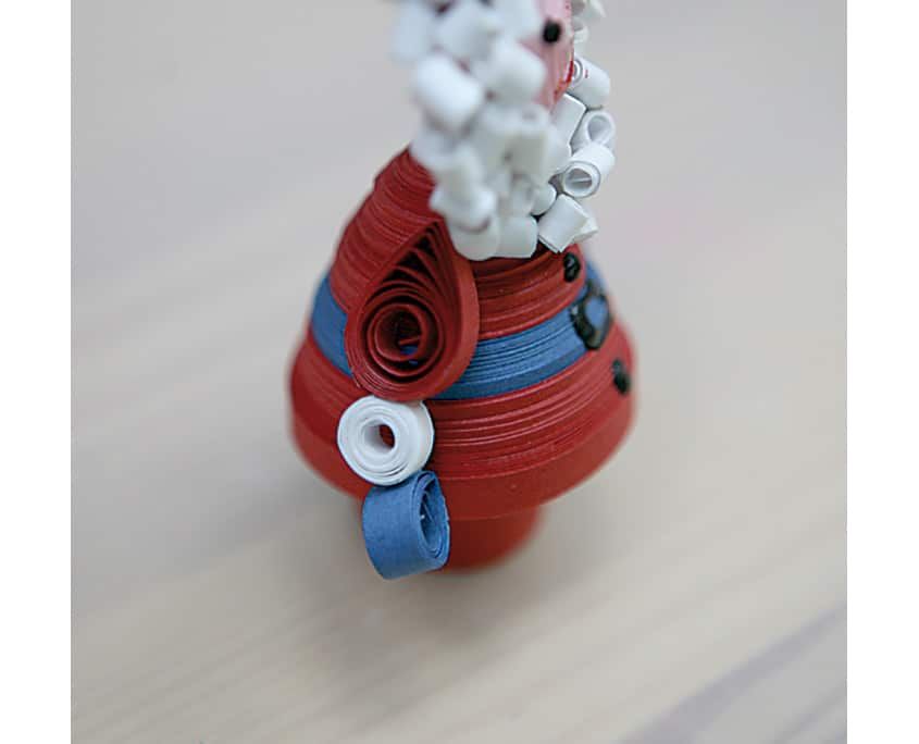 Kırmızı gövdeli, mavi kemerli ve beyaz kıvrık sakallı ikinci quilling Noel Baba, yakın plan