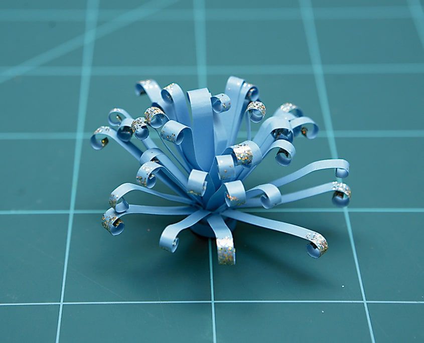 Uçları gümüş simli, kıvrık saçaklı açık mavi quilling paket süsü