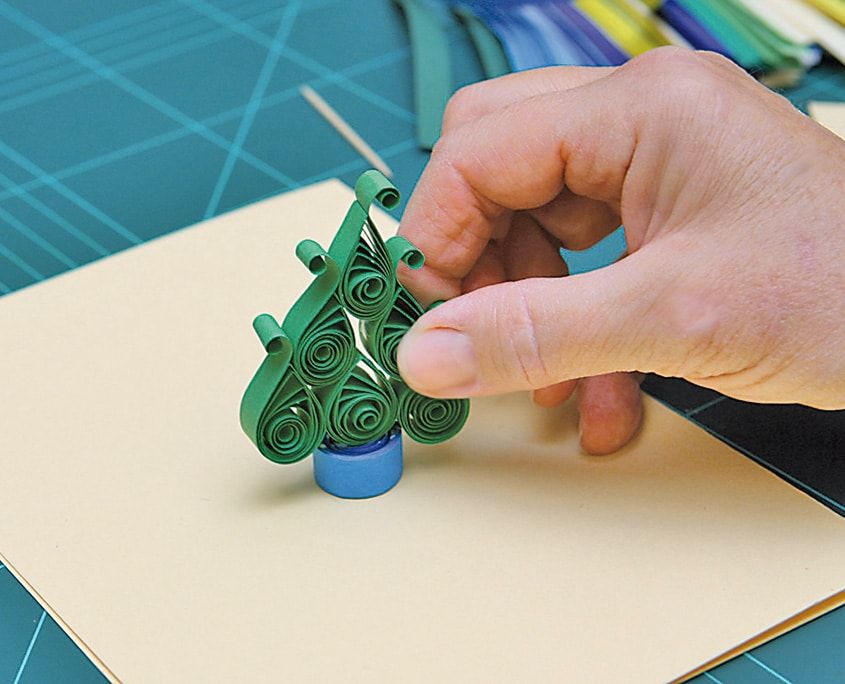 Yeşil quilling ağacın mavi rulo saksının üstüne dik olarak yerleştirilmesi