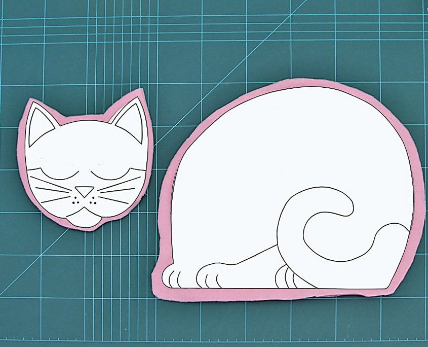 Pembe kumaş, kedi başı ve gövde şablonlarının çevresinden dikiş payı bırakılarak kesilmiş
