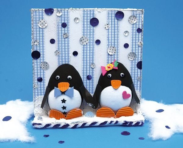Penguen Kardeşler: köpük toplardan iki penguen, turuncu ayaklar ve pullarla süslü mavi fon