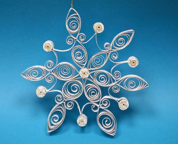 Quilling kar tanesi: mavi zemin üzerinde beyaz ve gümüş kağıt şeritlerden altı kollu süs