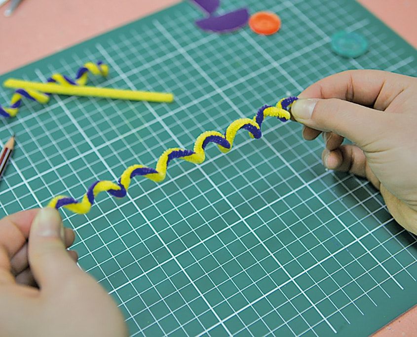 Sarı ve mor tüylü teller birbirine sarılarak spiral anten yapılıyor