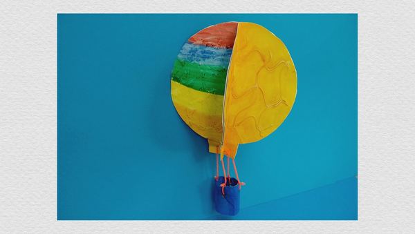 Uçan balon: renkli çizgili ve sarı boyalı kağıt balon, iplerle bağlı mavi küçük sepetiyle