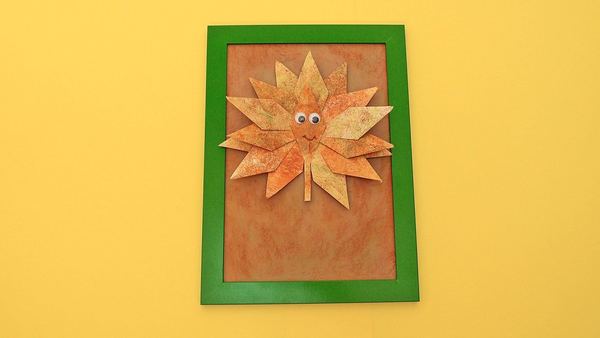 Bay Yaprak: kuru yapraklardan oynar gözlü yüz kolajı, kahverengi zeminde yeşil çerçeve içinde