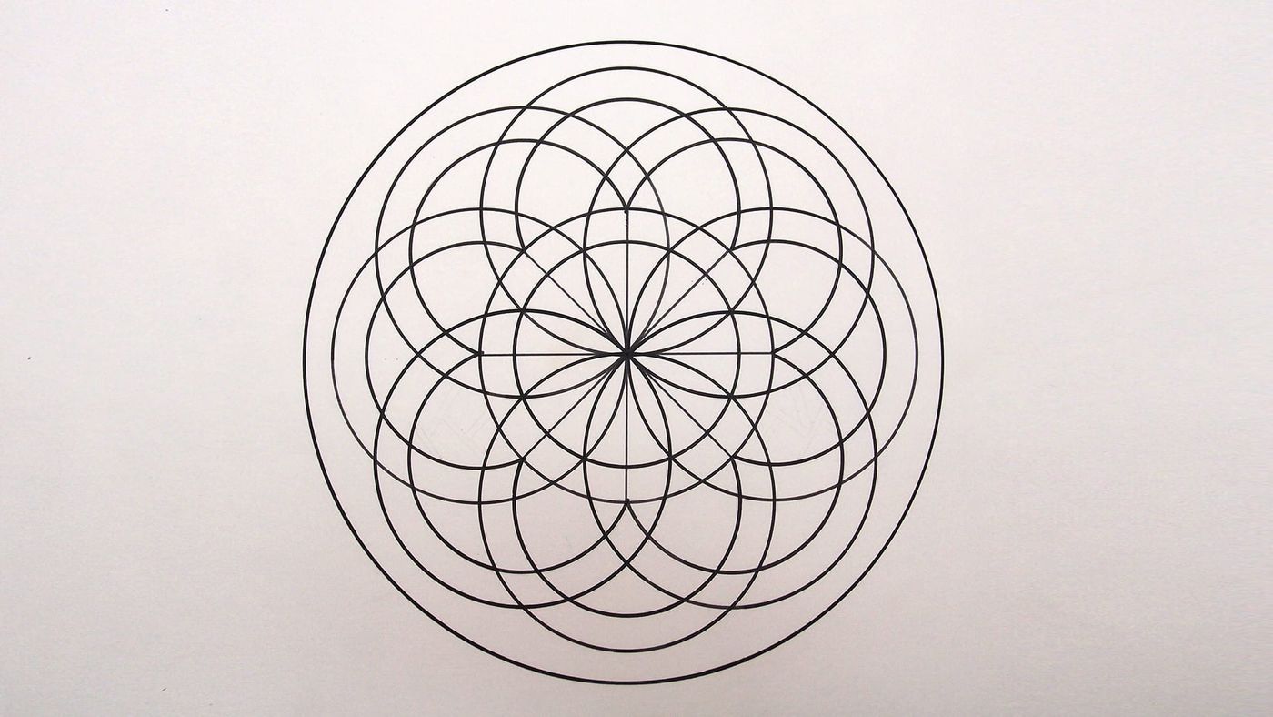 Büyük daire içinde iç içe geçen dairelerle siyah kalemle belirginleştirilmiş geometrik mandala