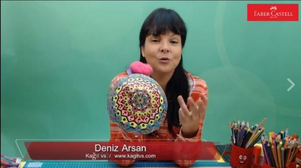 El kuklası boyama atölyesinden kare: eğitmen mandala desenli, ponponlu kubbe kuklayı gösteriyor
