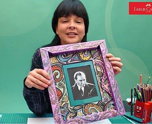 Desenli çerçeve atölyesinden kare: eğitmen içinde siyah-beyaz portre fotoğrafı olan mor çerçeveyi gösteriyor