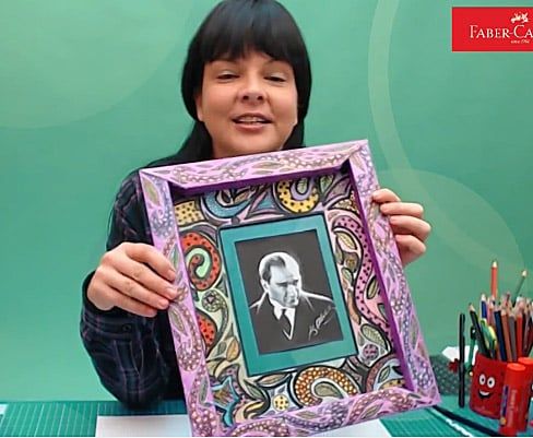 Desenli çerçeve atölyesinden kare: eğitmen içinde siyah-beyaz portre fotoğrafı olan mor çerçeveyi gösteriyor