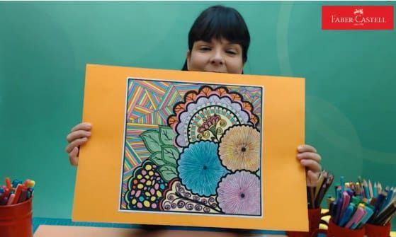 Doodle çiçek resmi canlı atölyesinden kare: eğitmen turuncu kartona yapıştırılmış renkli çalışmayı gösteriyor