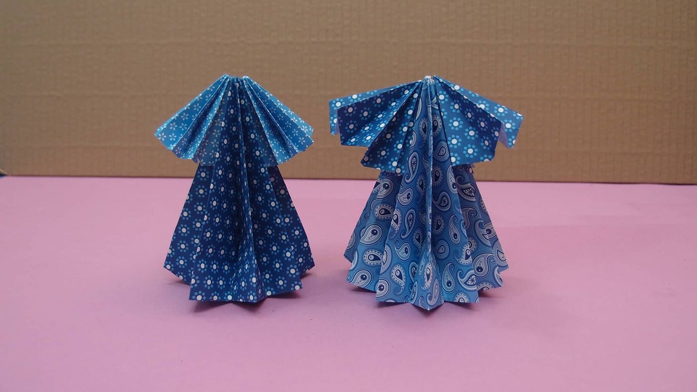 Yan yana iki origami elbise: biri beyaz puantiyeli lacivert, diğeri mavi damla desenli