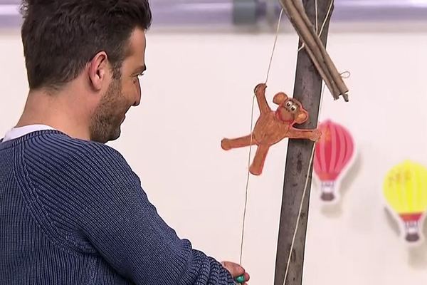 Programdan kare: sunucu ipi çekince kahverengi kağıt maymun dik dala doğru tırmanıyor