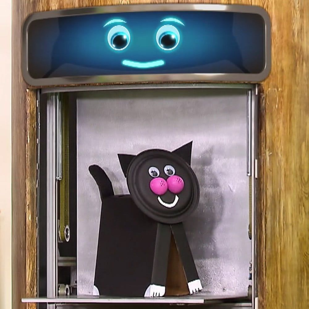 Programdan kare: ekranlı bir makinenin bölmesinden kağıt tabak yüzlü siyah karton kedi çıkıyor
