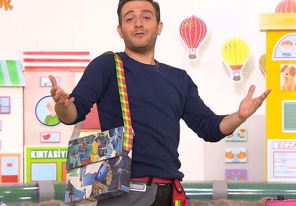 Ödev çantası: programdan kare, sunucu omzunda dergi kolajıyla kaplı pizza kutusu çantayla