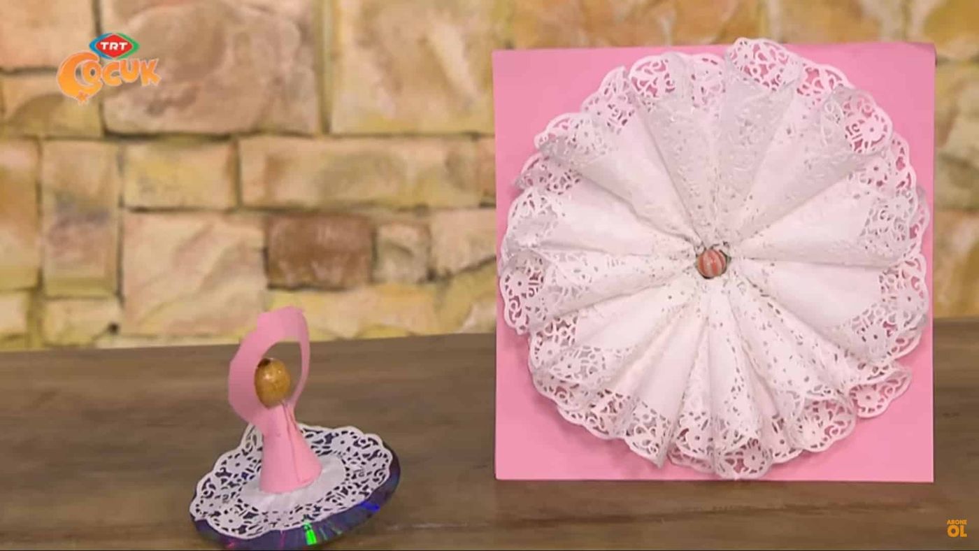 Pembe kartonda dantel kağıt yelpaze daire ve önünde dantel etekli pembe kağıt balerin fırıldak