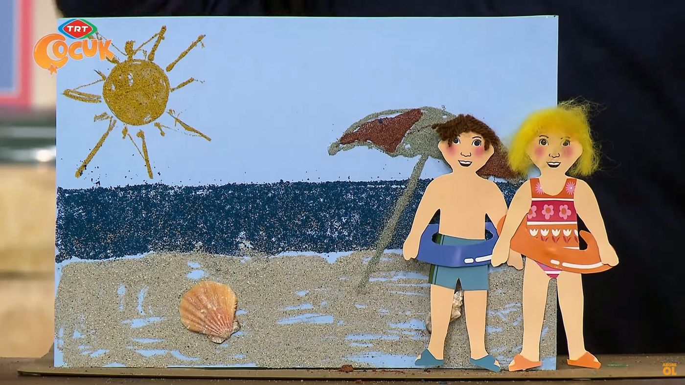 Kum boyama: renkli kumla yapılmış plaj tablosu, deniz, güneş, şemsiye ve simitli iki çocuk figürü