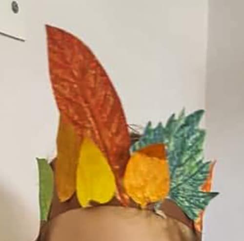 Tacın bir yanında yükselen uzun kiremit rengi yaprak, yanında sarı ve yeşil dişli yapraklar