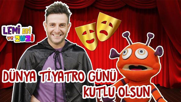 Dünya Tiyatro Günü kutlama görseli: pelerinli sunucu, altın tiyatro maskeleri ve turuncu uzaylı karakter kırmızı perde önünde