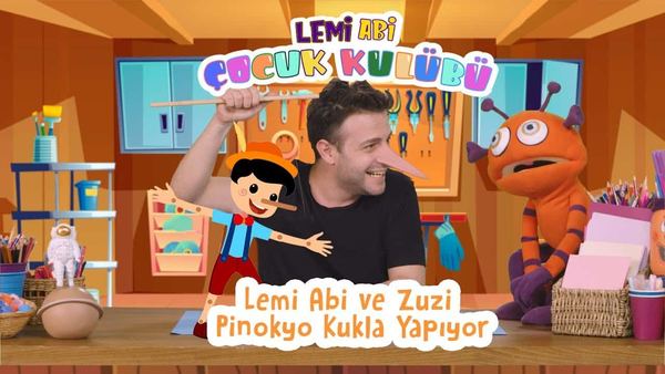 Burnu Uzayan Pinokyo kukla yapımı video kapağı: sunucu kağıt Pinokyo kuklayı gösteriyor, yanında turuncu kukla